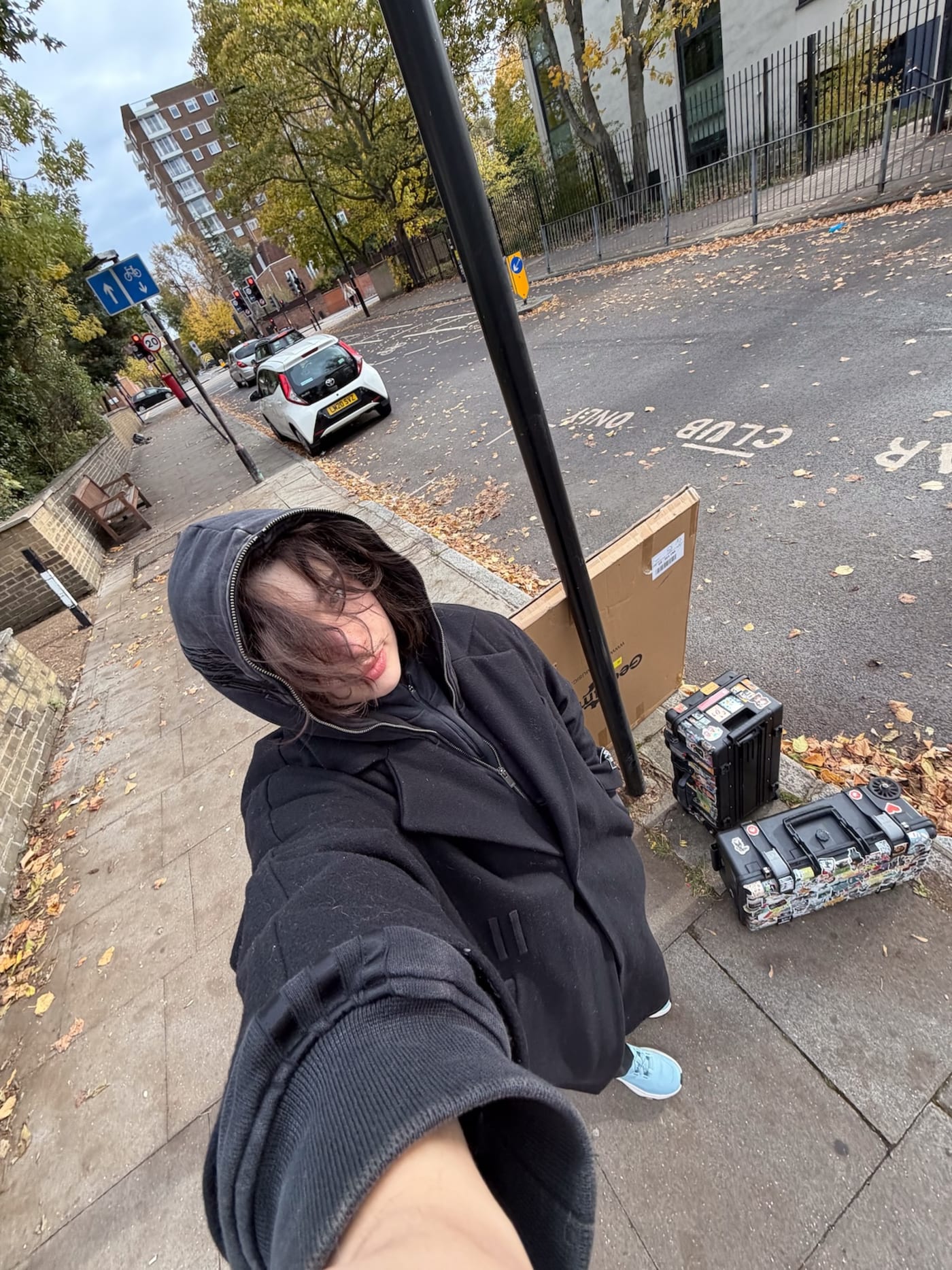 A We Stream team member taking a fisheye selfie on a London street, next to camera cases