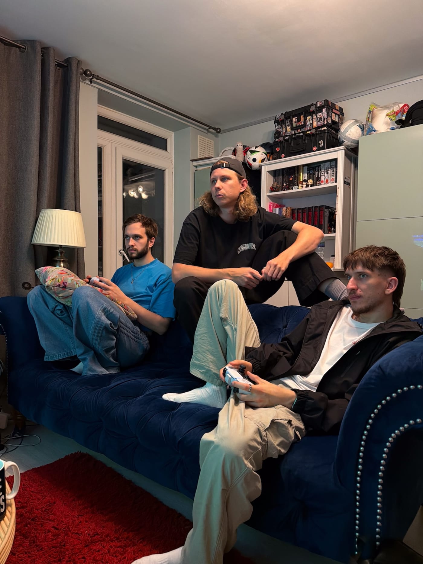 Three members of the We Stream team playing video games on a sofa at home