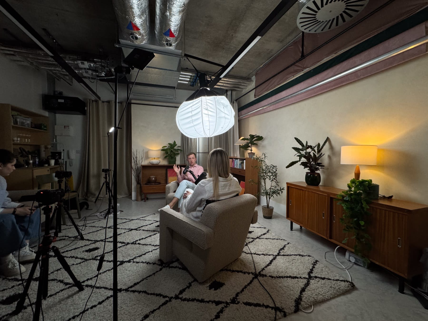 Client podcast set with a lantern light, armchairs and two cameras, with a We Stream producer on set