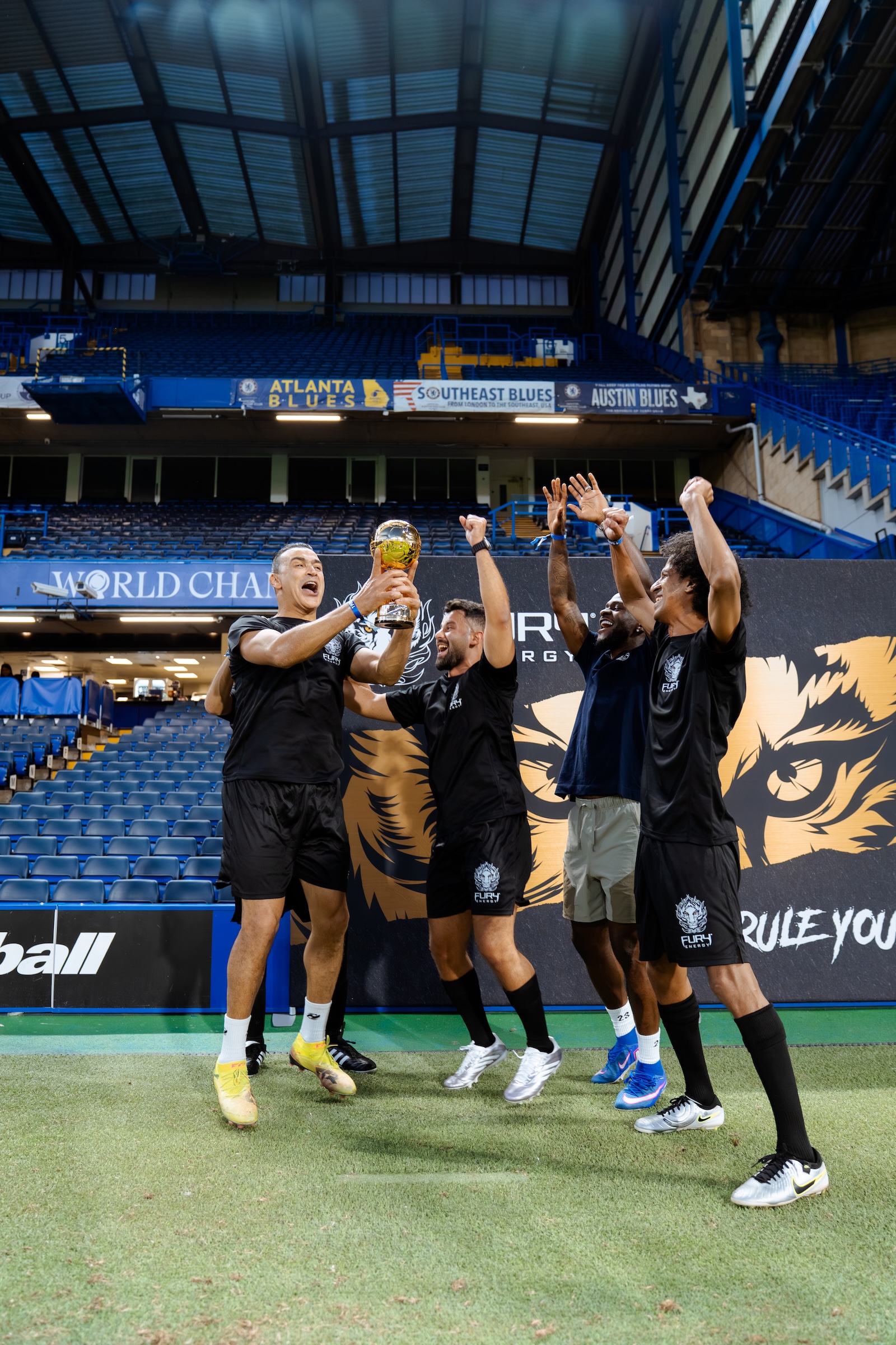 Fury Energy team jumping and celebrating on the pitch at Stamford Bridge, Chelsea FC