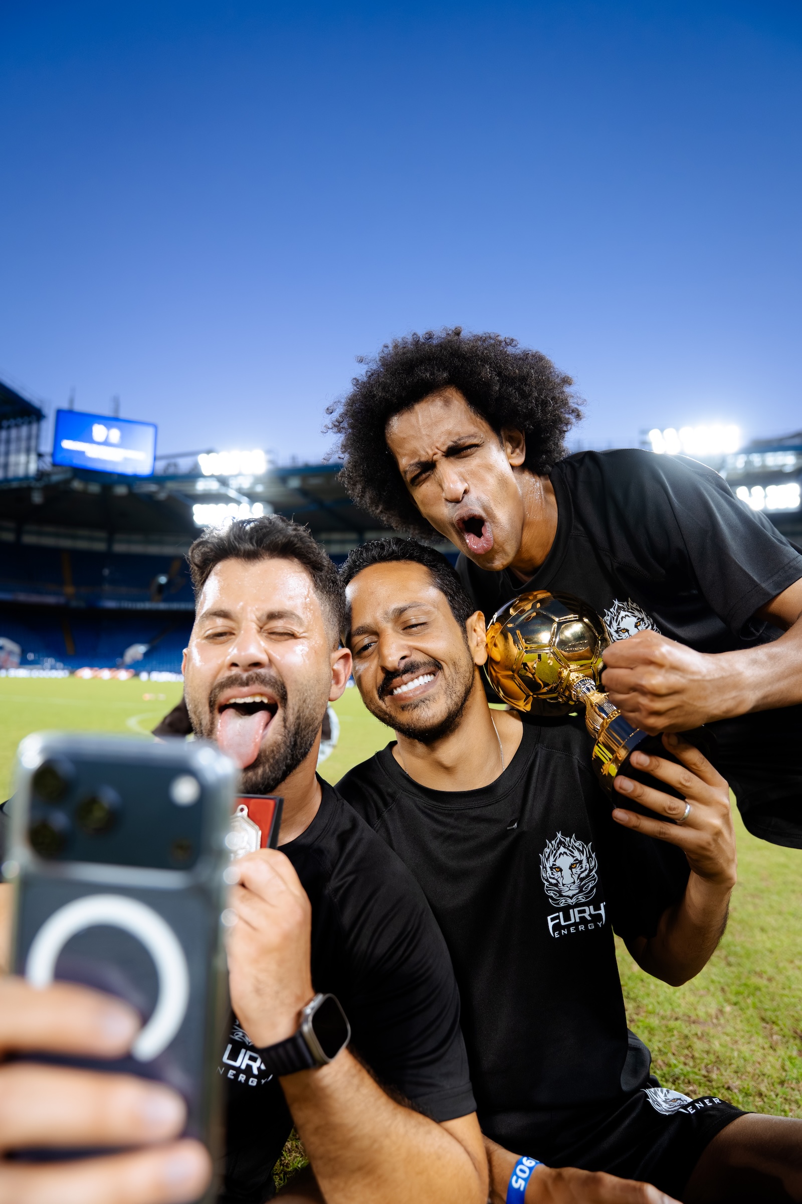 Aziz El Akkaad, Gamey Freestyle and Marwan Serry taking a selfie with the trophy at the Fury Energy x Chelsea FC event, Stamford Bridge