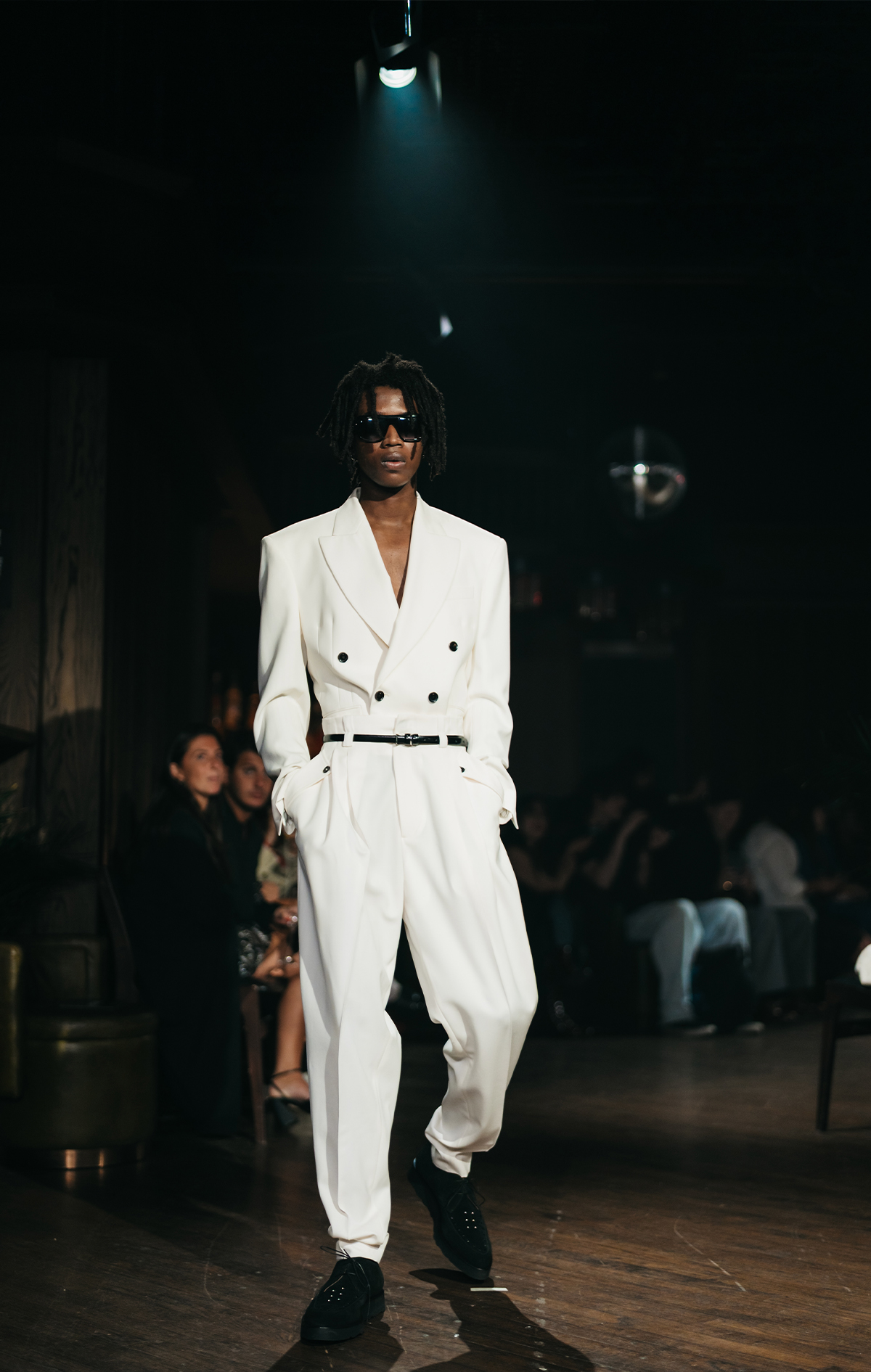 Model walking the runway in a white tailored suit at the John Richmond fashion show in London, event photography by We Stream