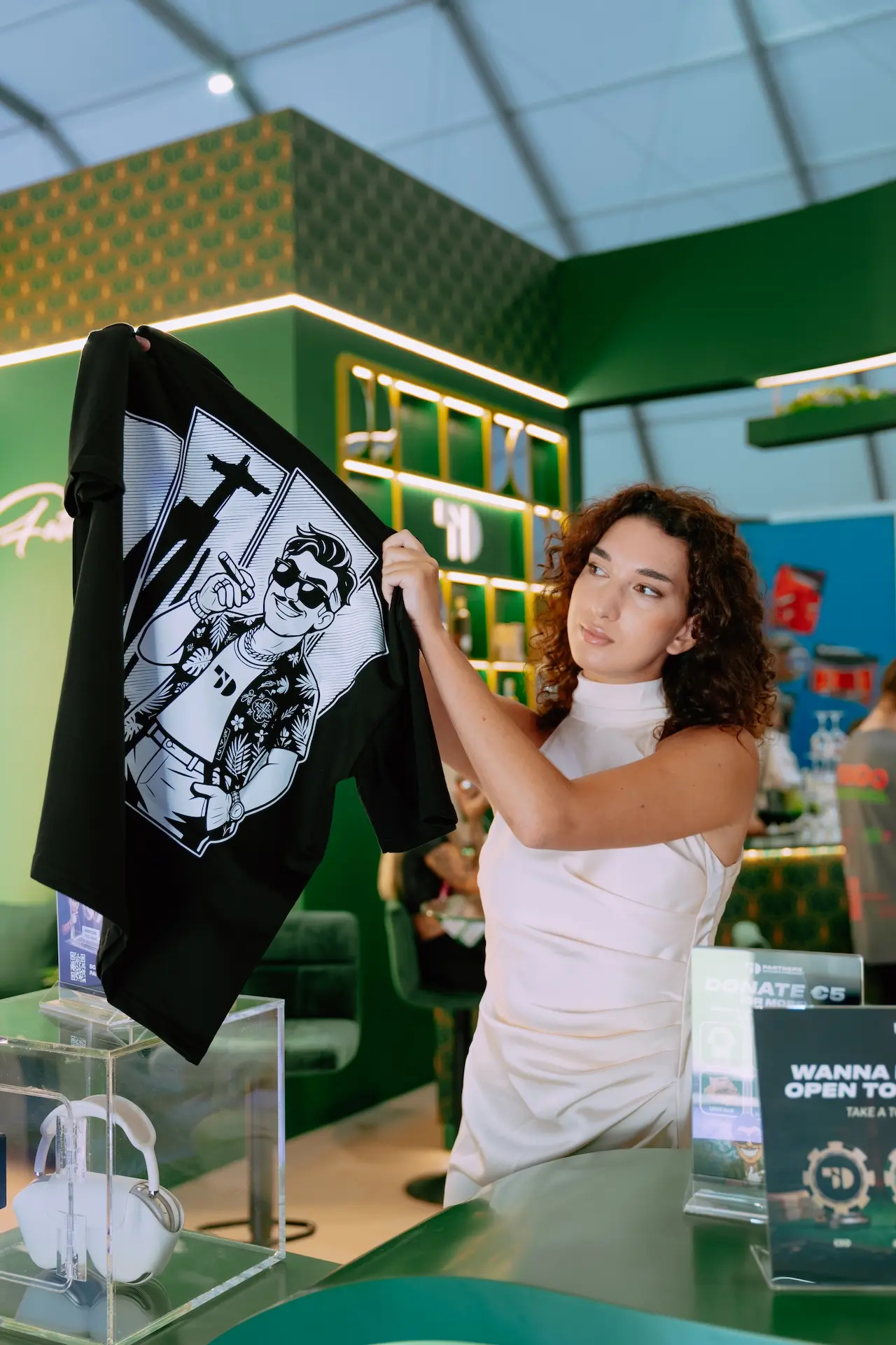 Hostess holding up a 50 Partners branded T-shirt at stand F441, SBC Summit Lisbon 2026