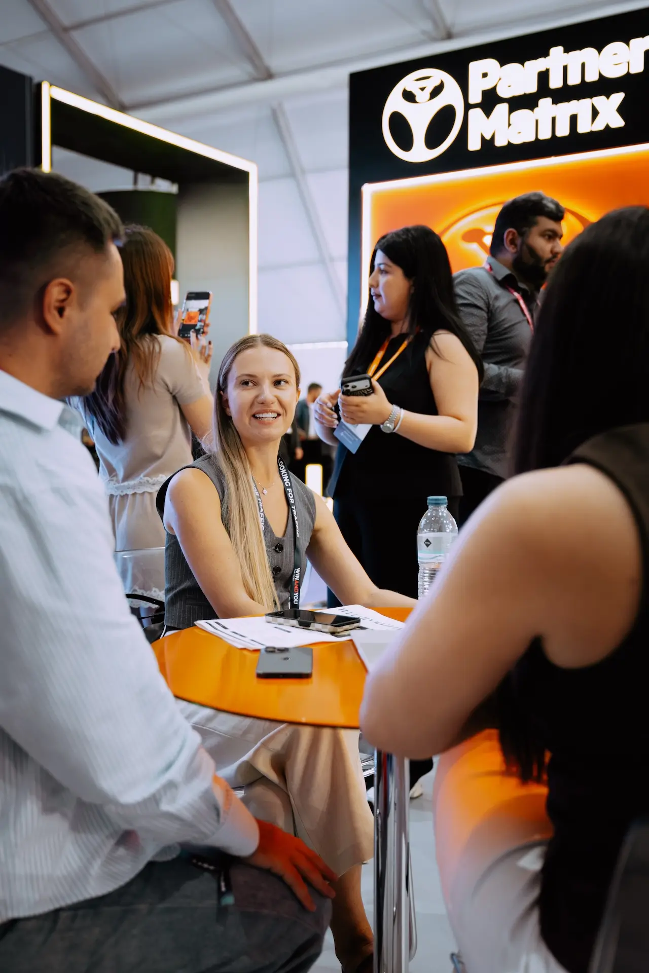 A PartnerMatrix team member smiling across the table during a client meeting at SBC Summit Lisbon 2026