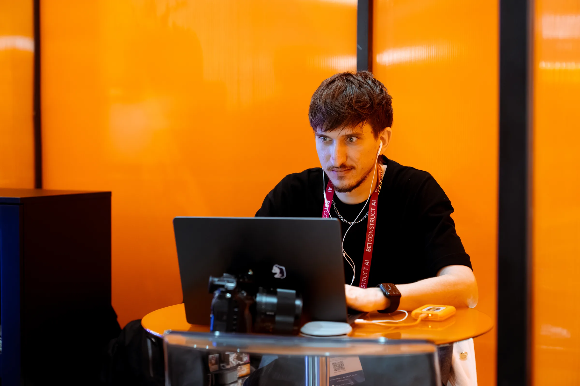 An editor cutting on site at an event, laptop and camera on the table