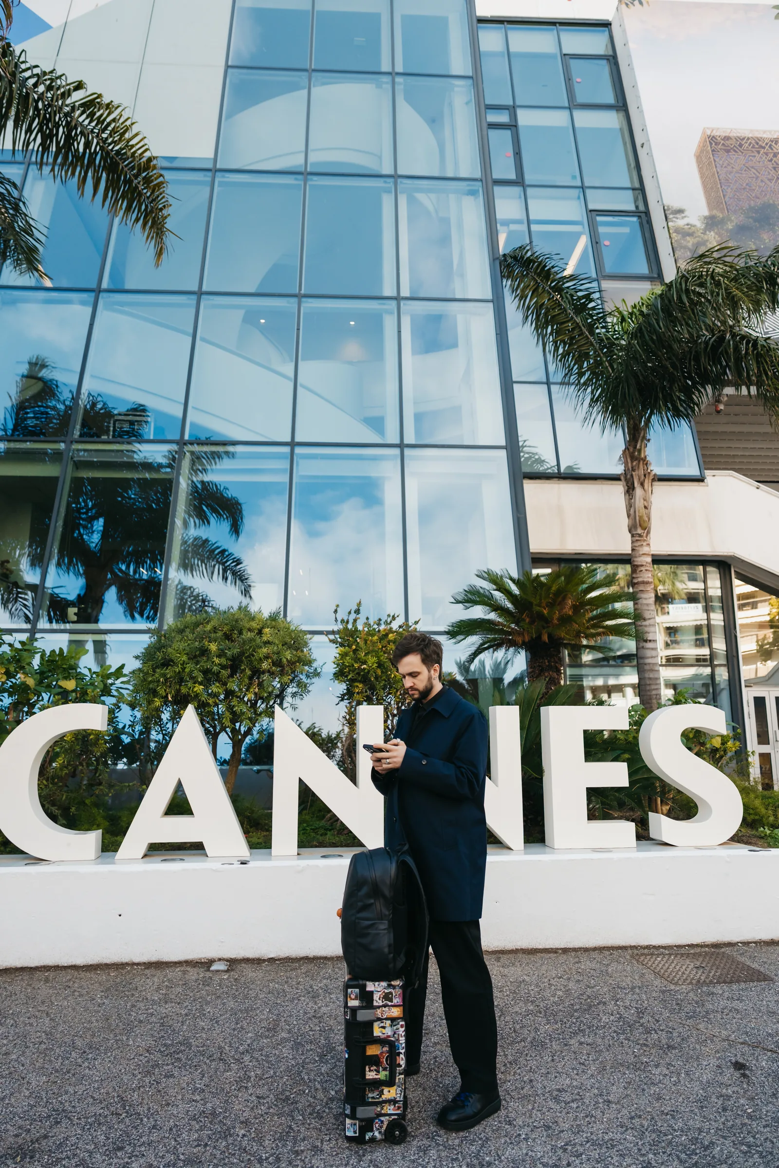 A crew member with kit cases outside the Palais at Cannes