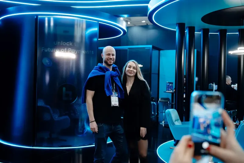 Visitors photographed on BitPace's blue-lit stand at ICE Barcelona 2026