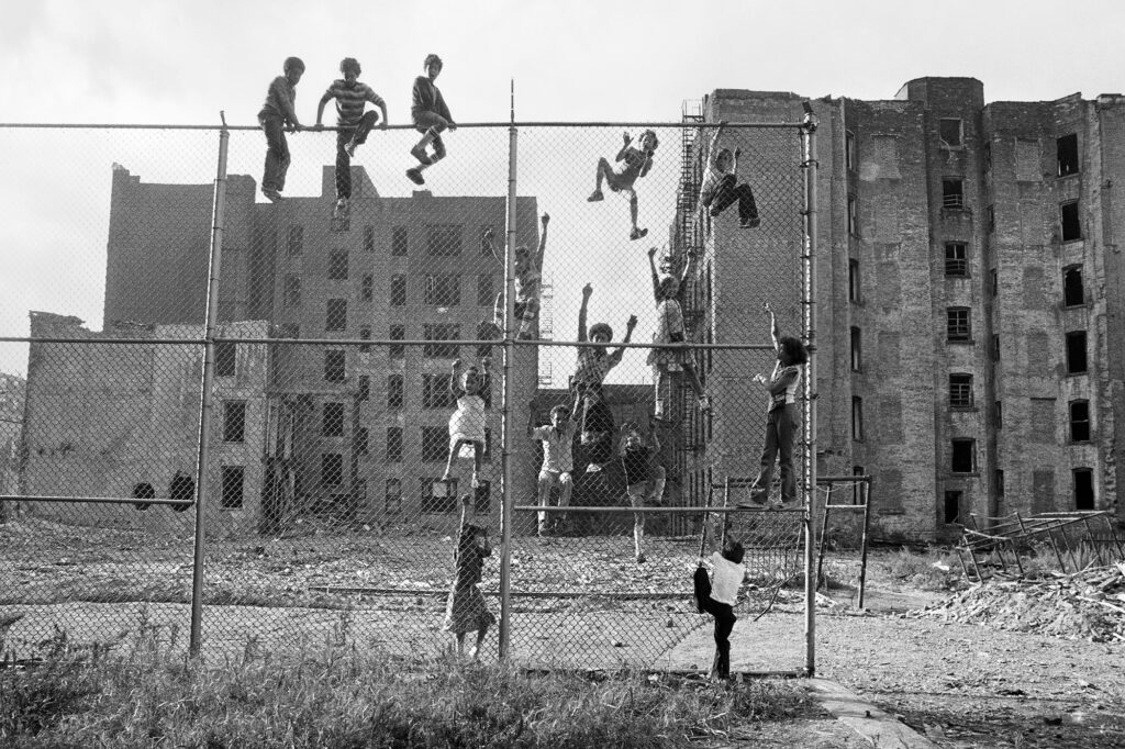 , Kids climbing a fence in an abandoned lot, Lower East Side, NYC, from the series Street Play, 1978 ©Martha Cooper