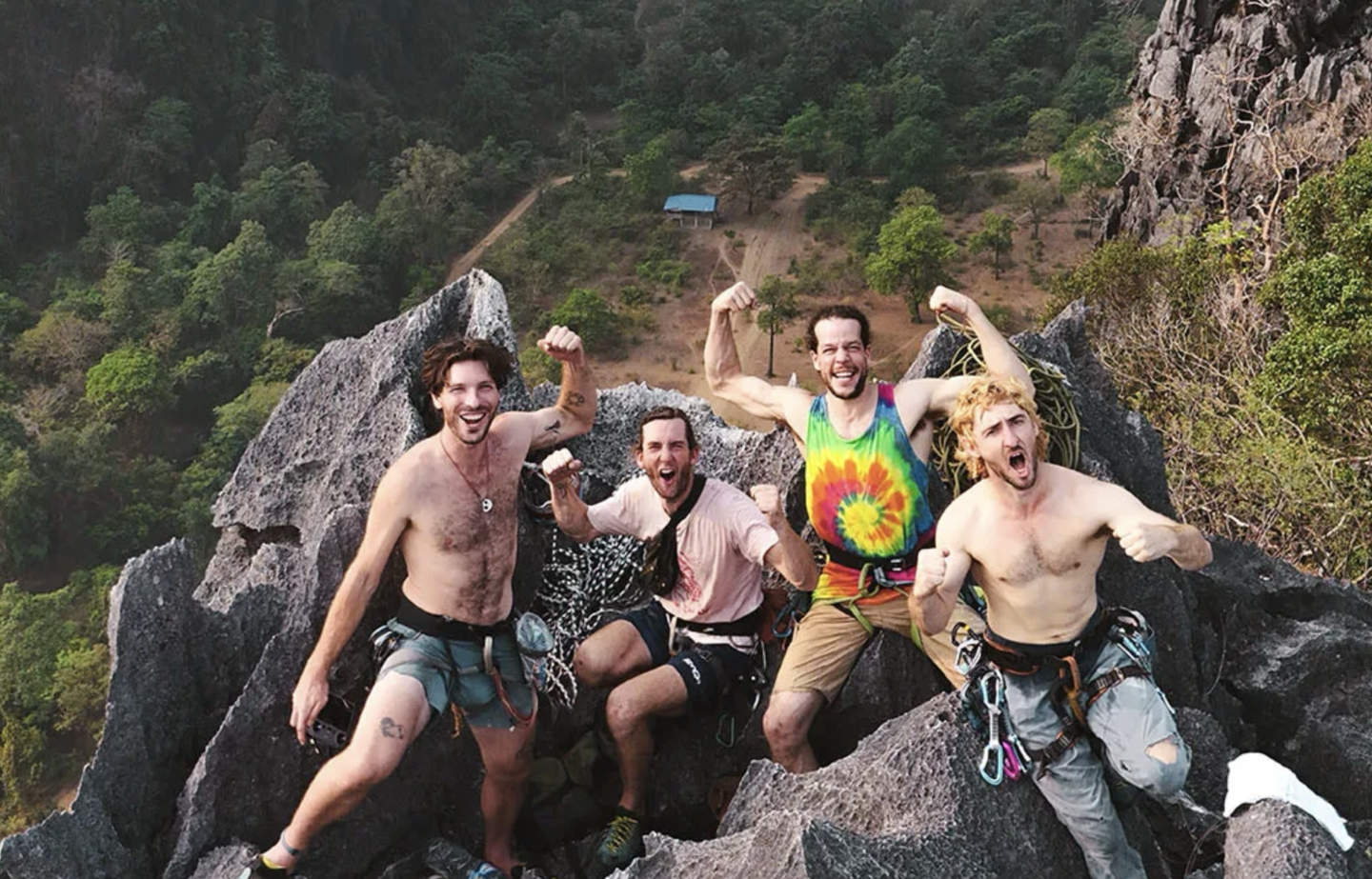 Drone shot of 4 climbers on the top of a summit and celebrating the succesful clim