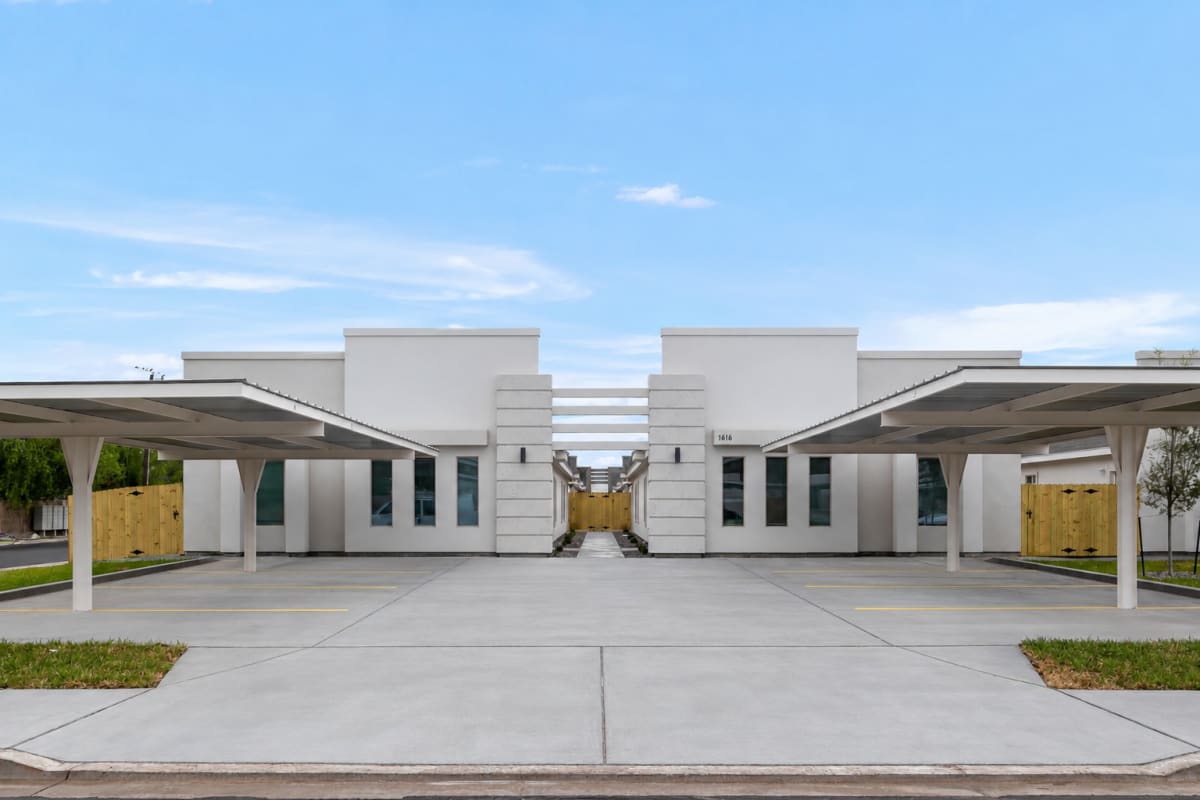 Front exterior elevation of a Verona duplex building with covered carports on either side