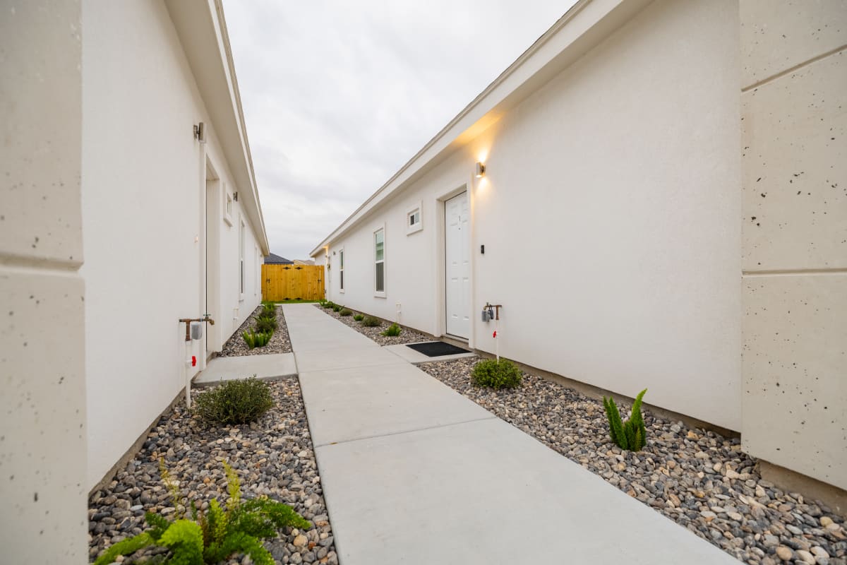 Exterior side yard showing HVAC condenser unit and wood privacy fence at Westwood Villas