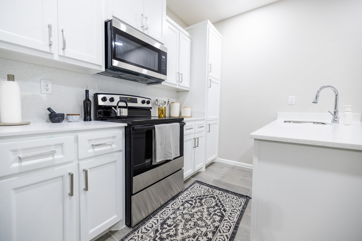 Modern white shaker kitchen with quartz countertops and stainless steel appliances at Westwood Villas