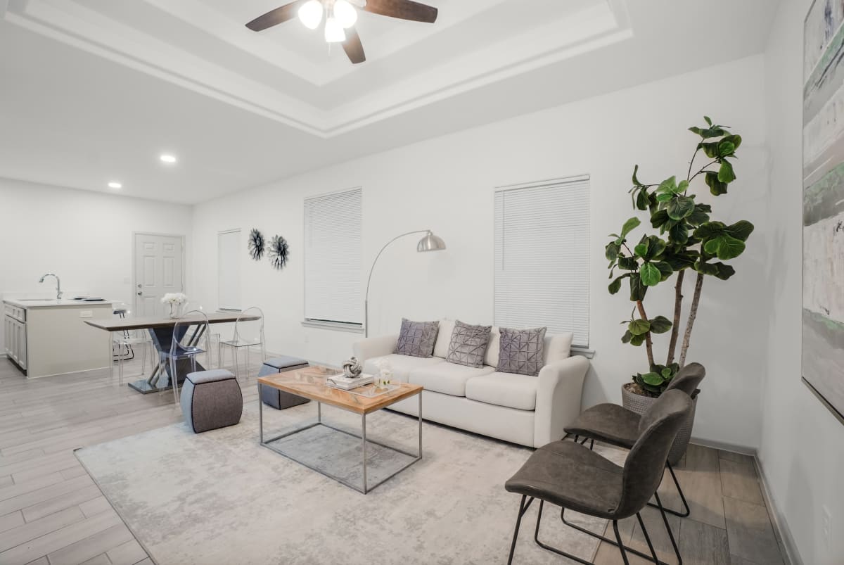 Sugar Mills living room with open kitchen view and light neutral finishes