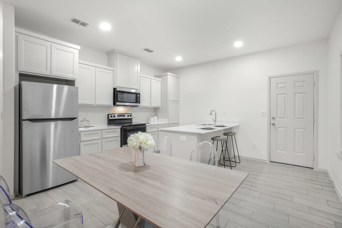 Sugar Mills kitchen with white cabinetry, island seating, and stainless appliances