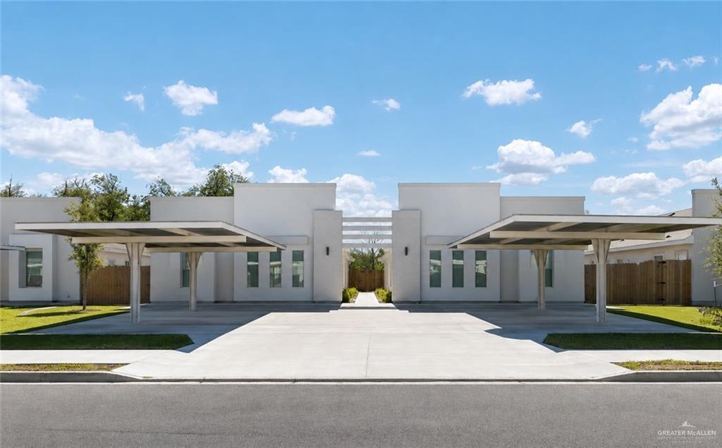 Dawson Estates fourplex on Starr Street in Mercedes: two single-story white stucco buildings, each with a covered carport