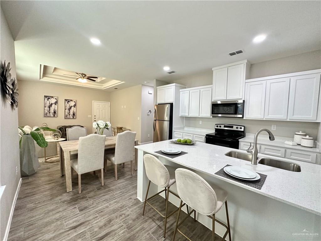 Dawson Estates kitchen island with bar stools and a double sink, beside a staged dining table