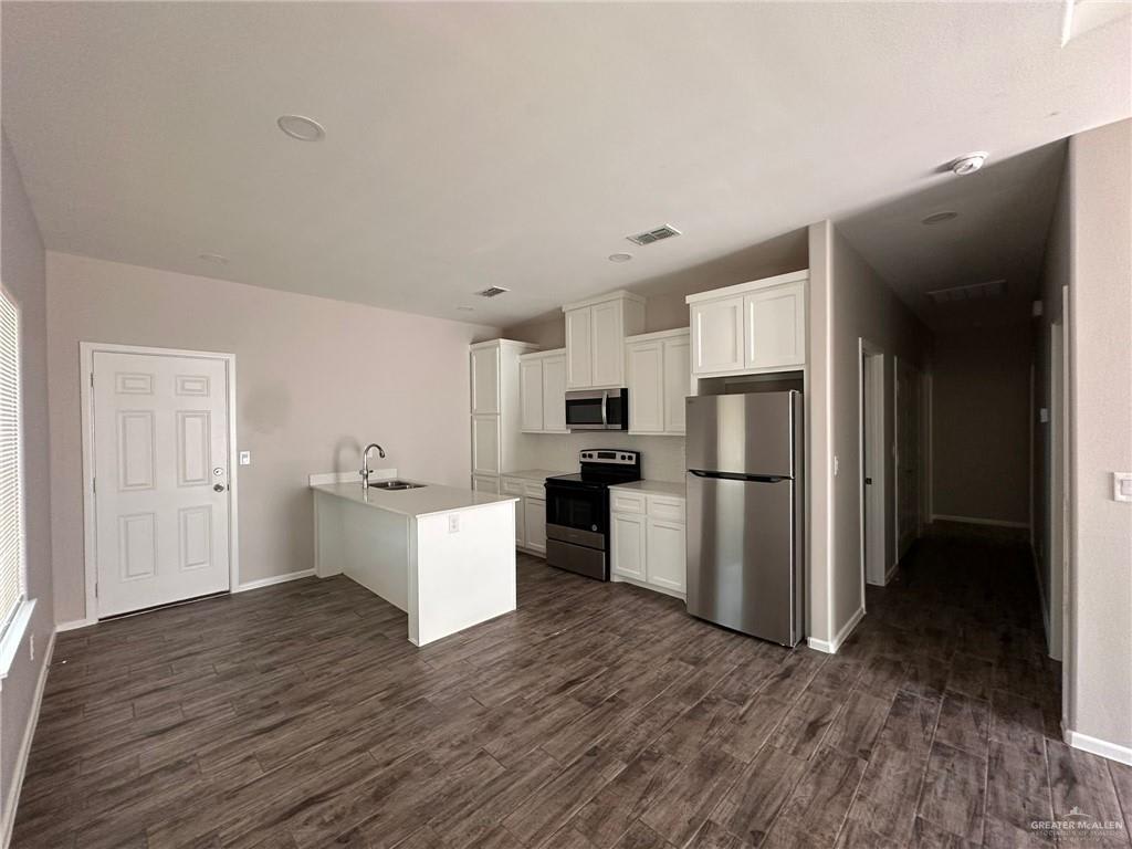 Heights at Alamo kitchen with white cabinets, a peninsula sink, and stainless range, microwave and refrigerator