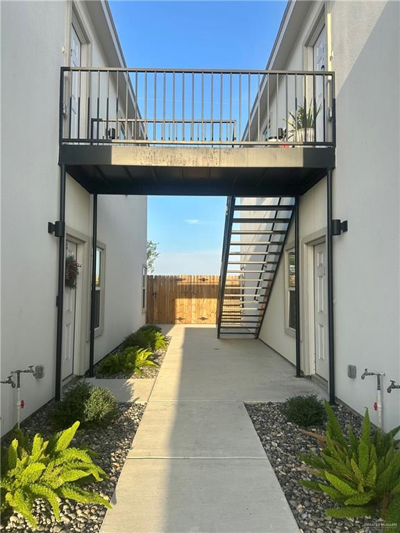 Breezeway between Vida's two-story buildings, with an upstairs landing, metal stairs and landscaped gravel beds