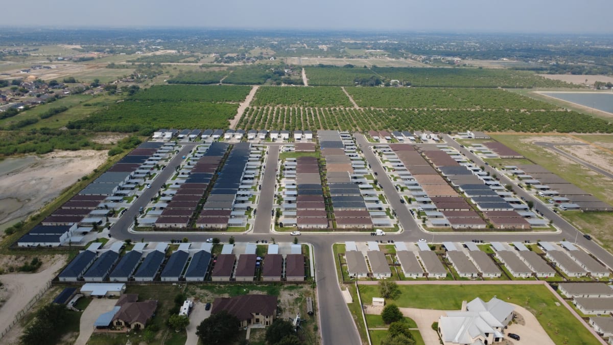 High aerial view of the Sunset Valley subdivision in Alton, with orchards beyond