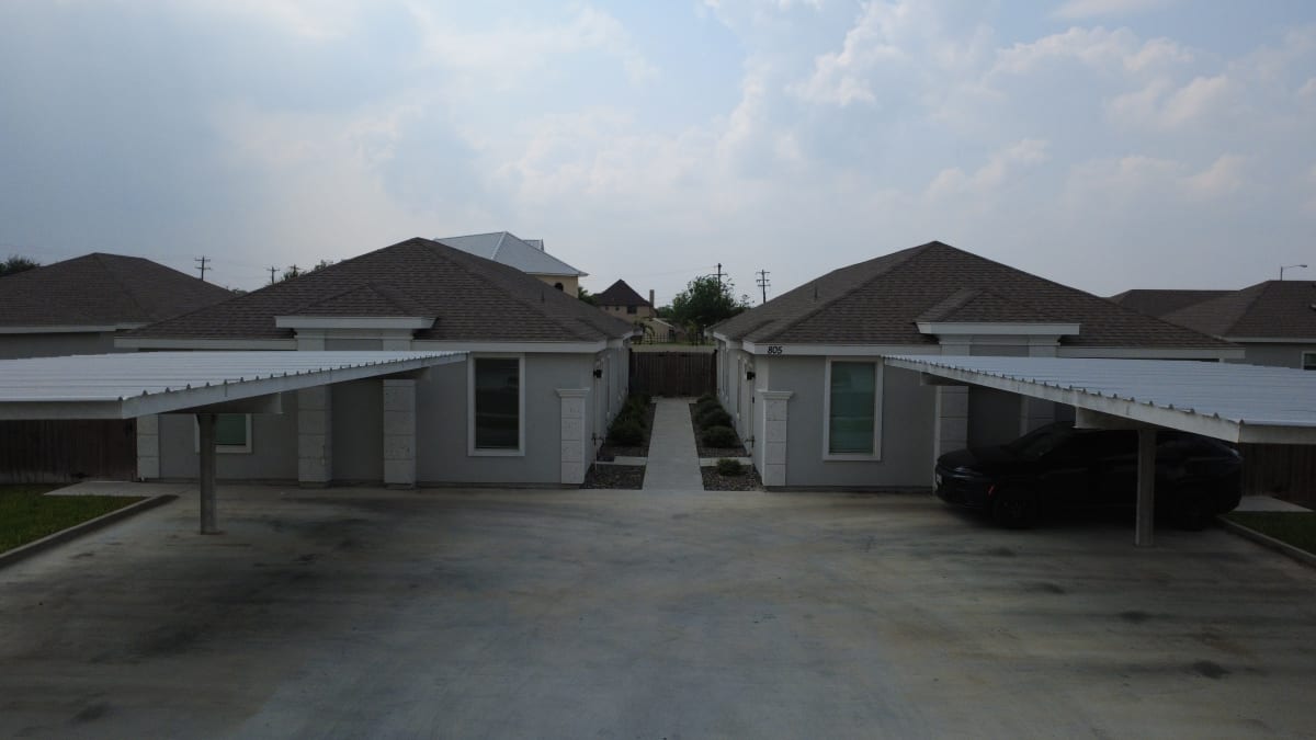 Front of a Sunset Valley fourplex, with its covered carports and the walkway between its two wings