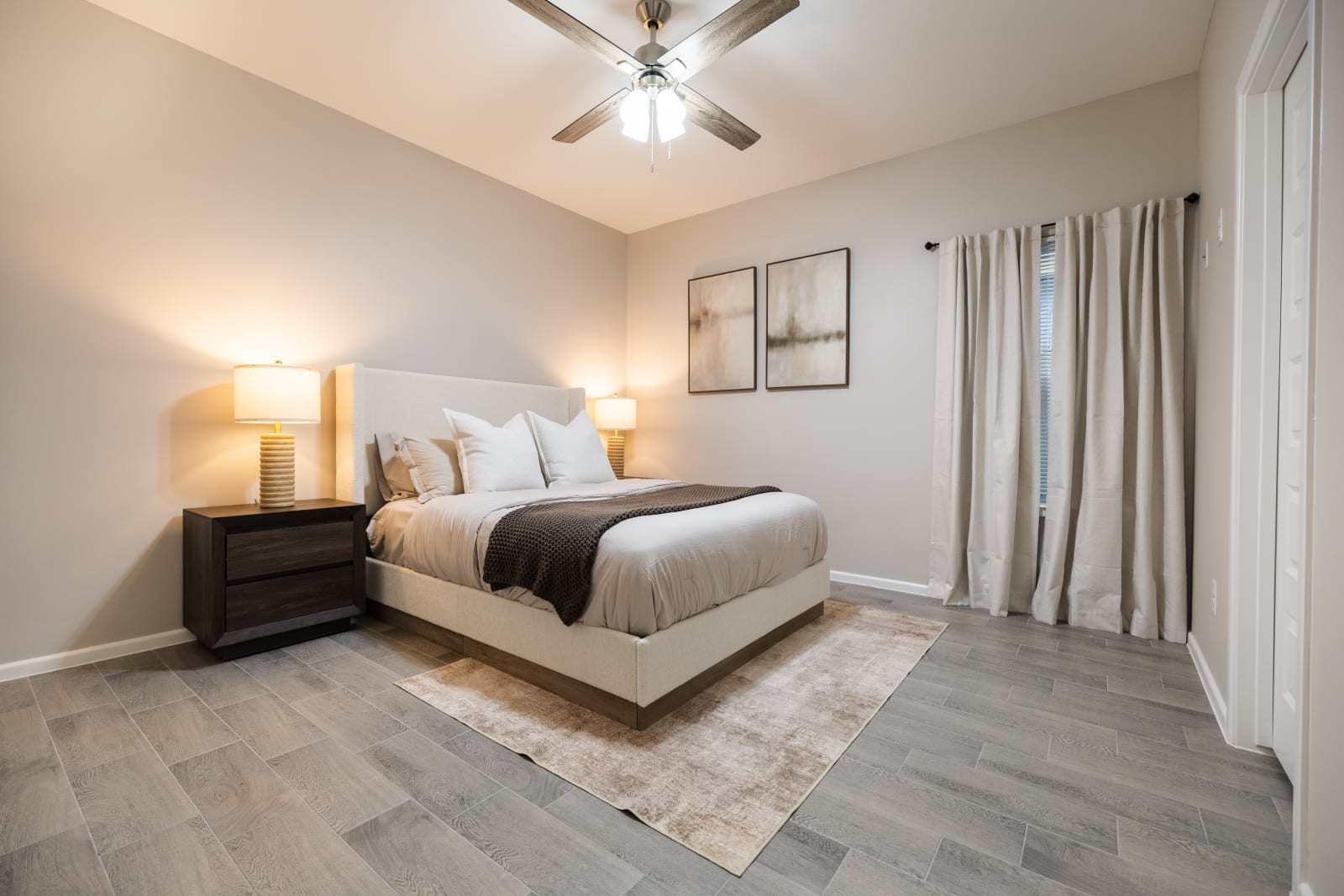 Staged primary bedroom with upholstered bed and neutral decor at Westwood Villas