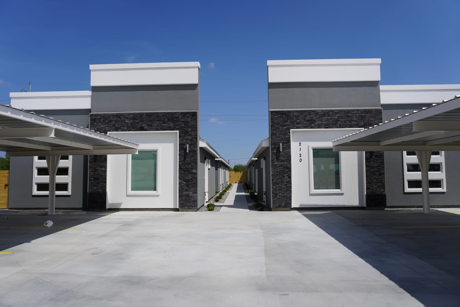 Four Pillars fourplex exterior with covered carports at OakView Sixplexes