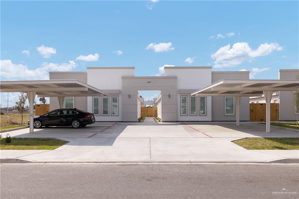 Riverside Tower fourplex on Frio Lane in Alamo: mirrored single-story stucco units around a center walkway, with covered carports on each side