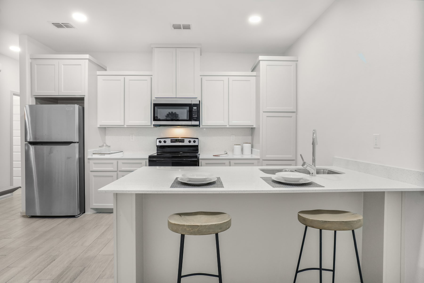 Sugar Mills kitchen with island seating and stainless refrigerator