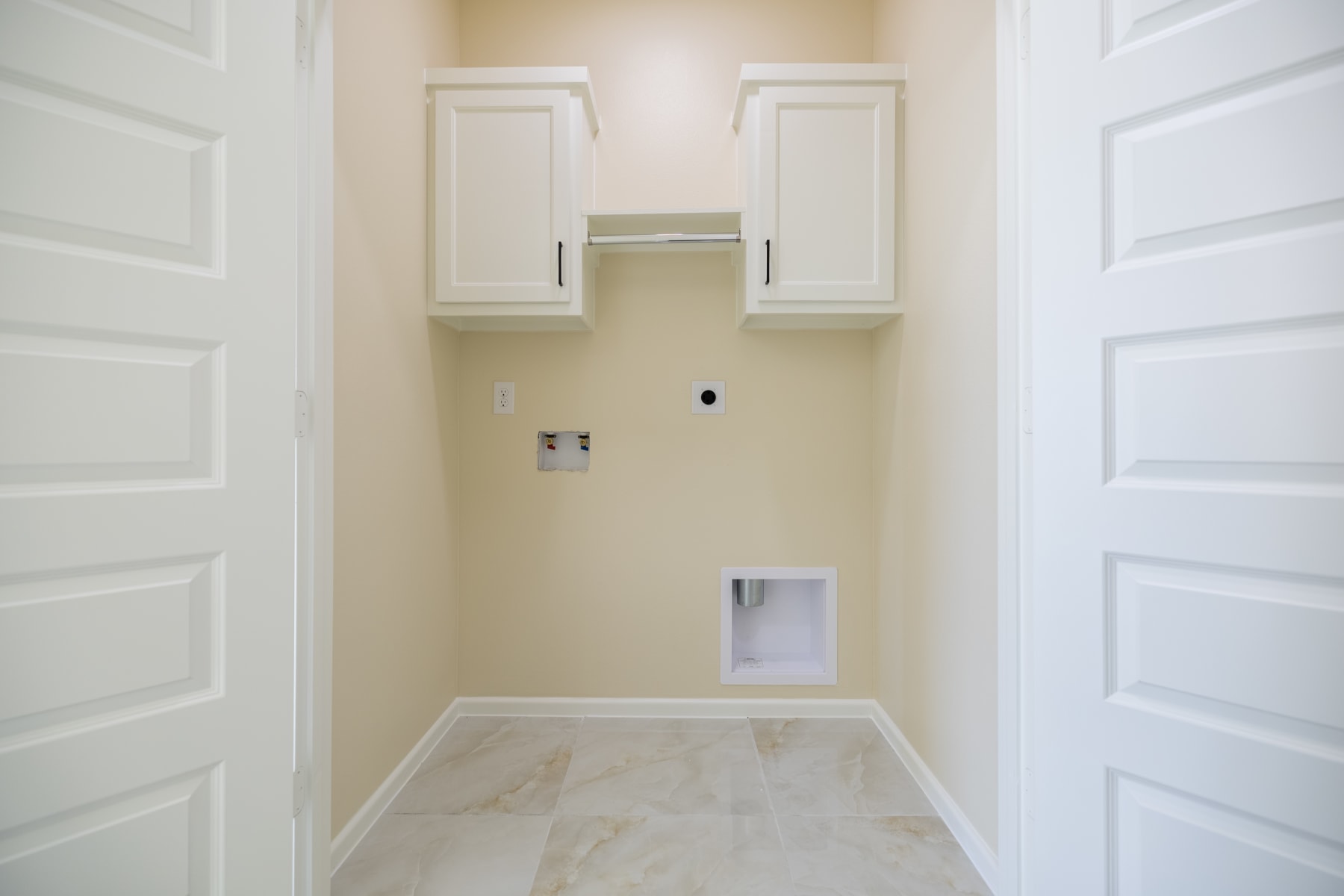 Laundry room with upper cabinets and washer and dryer hookups