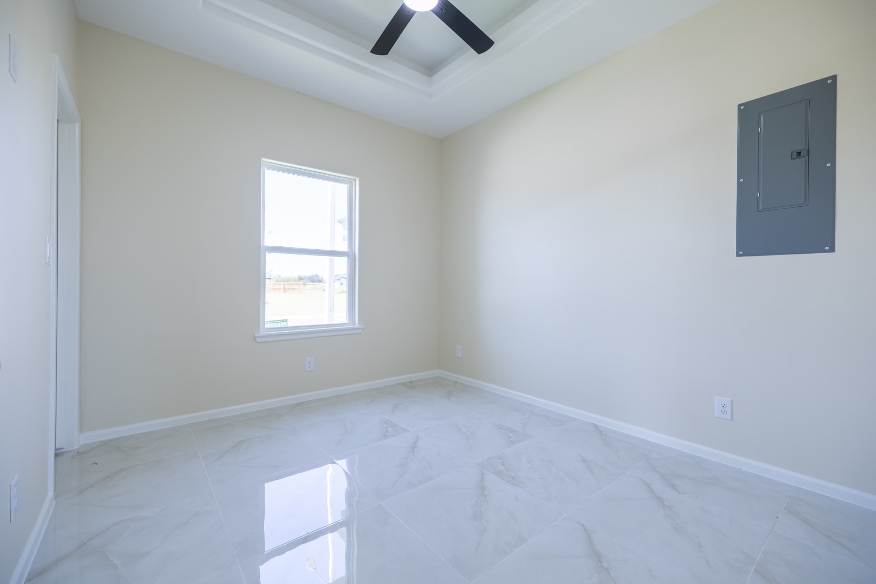 Unfurnished bedroom with a window and marble-look tile flooring
