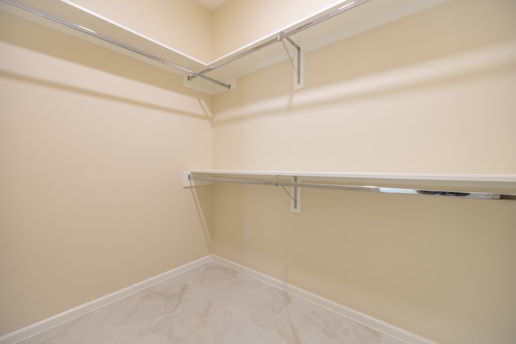 Second walk-in closet with full-length hanging rods and upper shelving
