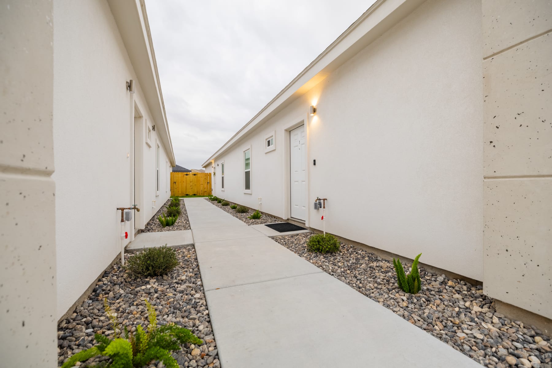 Exterior side yard showing HVAC condenser unit and wood privacy fence at Westwood Villas
