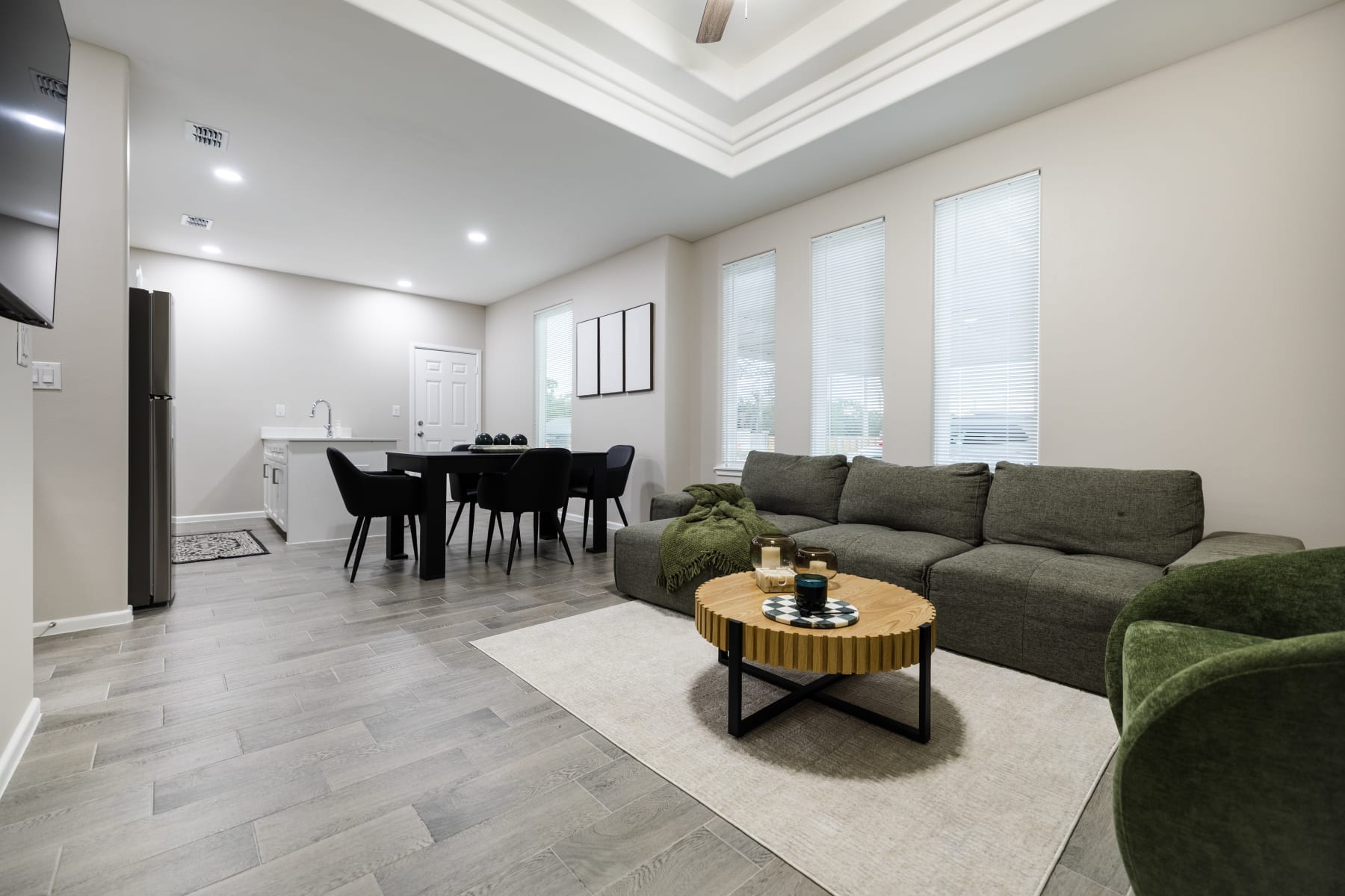 Open-concept living room with sectional sofa, TV wall, and view into the dining and kitchen area at Westwood Villas