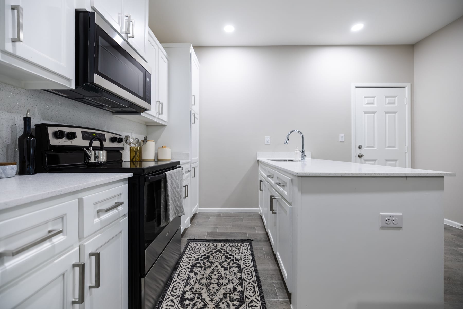 Open kitchen with island seating, pendant lighting, and adjoining dining area at Westwood Villas
