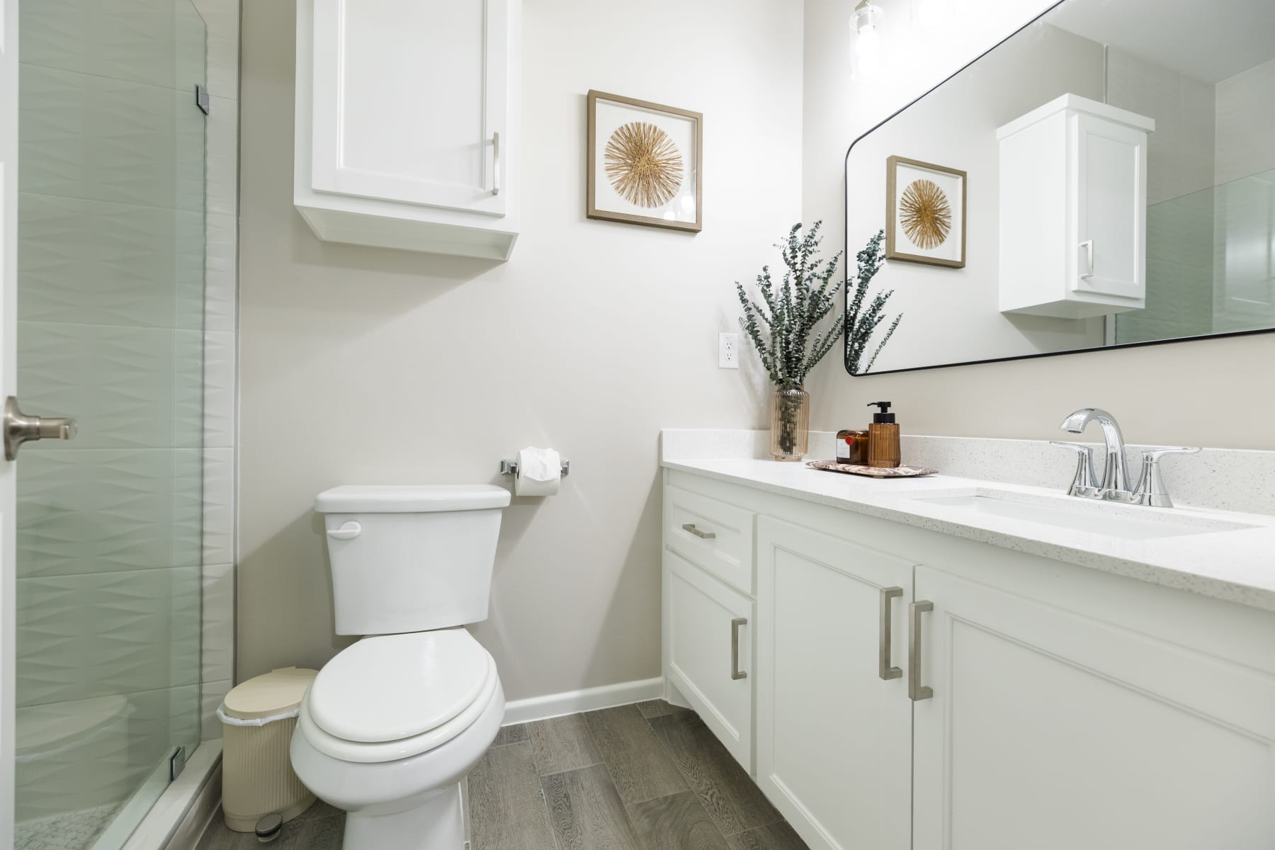 Bathroom with walk-in glass shower, staged decor, and white vanity at Westwood Villas