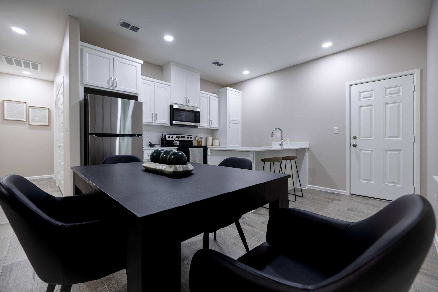 Open-concept dining and kitchen layout with modern black seating at Westwood Villas