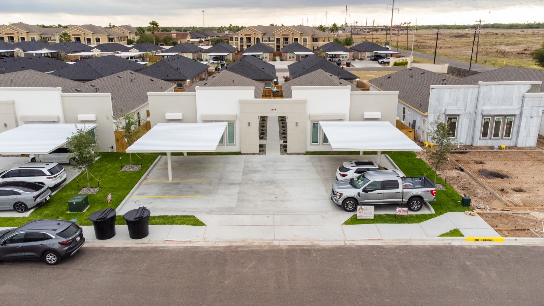 Aerial perspective of the Westwood Villas community entrance and carports amid the surrounding subdivision
