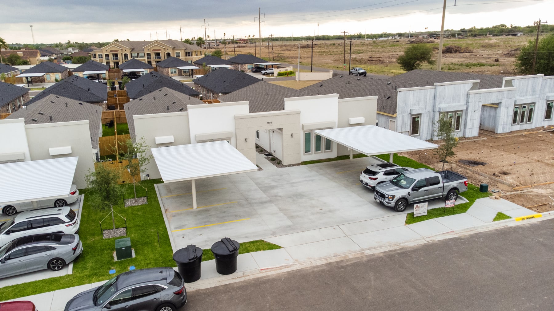 Aerial view of the Westwood Villas fourplex row with covered carports and surrounding neighborhood