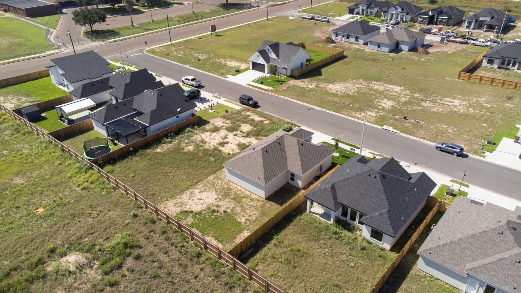Aerial view of completed homes along the street with fenced rear yards