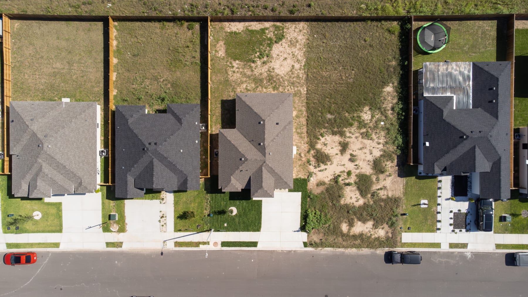 Overhead view of two homes with their driveways and rear yards