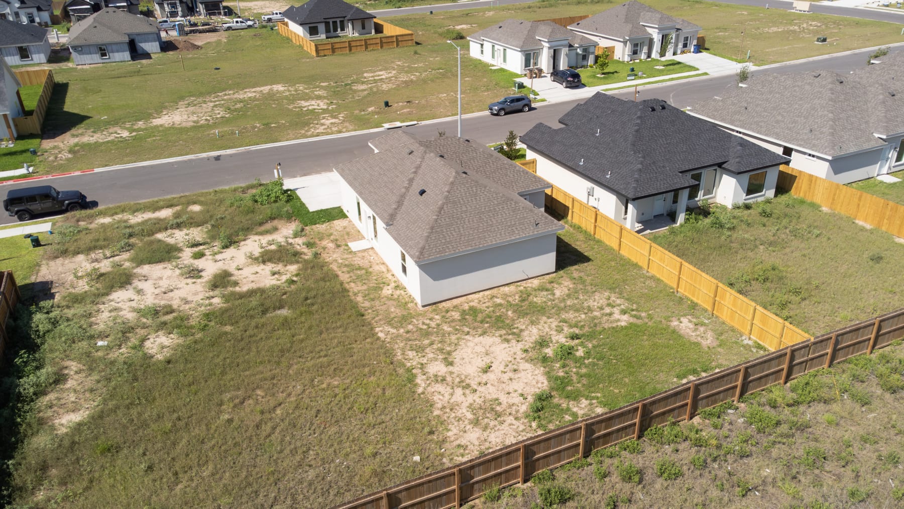 Aerial view over the rooftops of completed homes with vacant lots between them