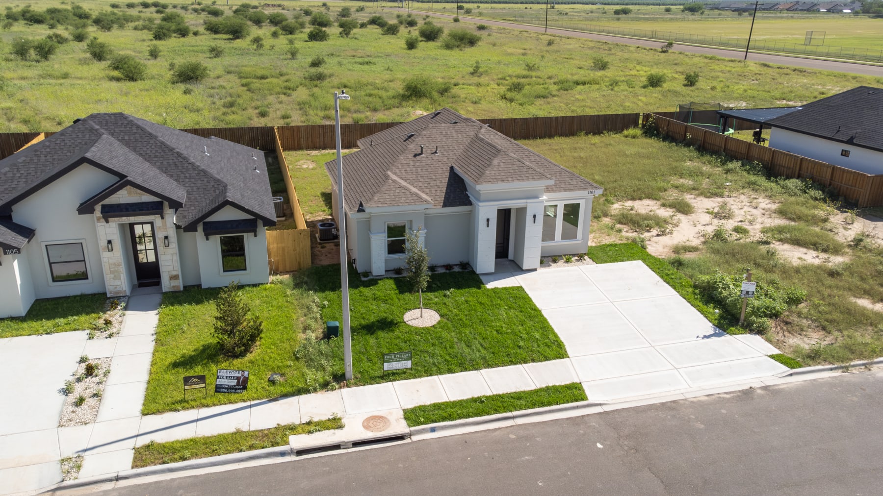 Aerial view of the home's front elevation with its landscaped front yard and sidewalk