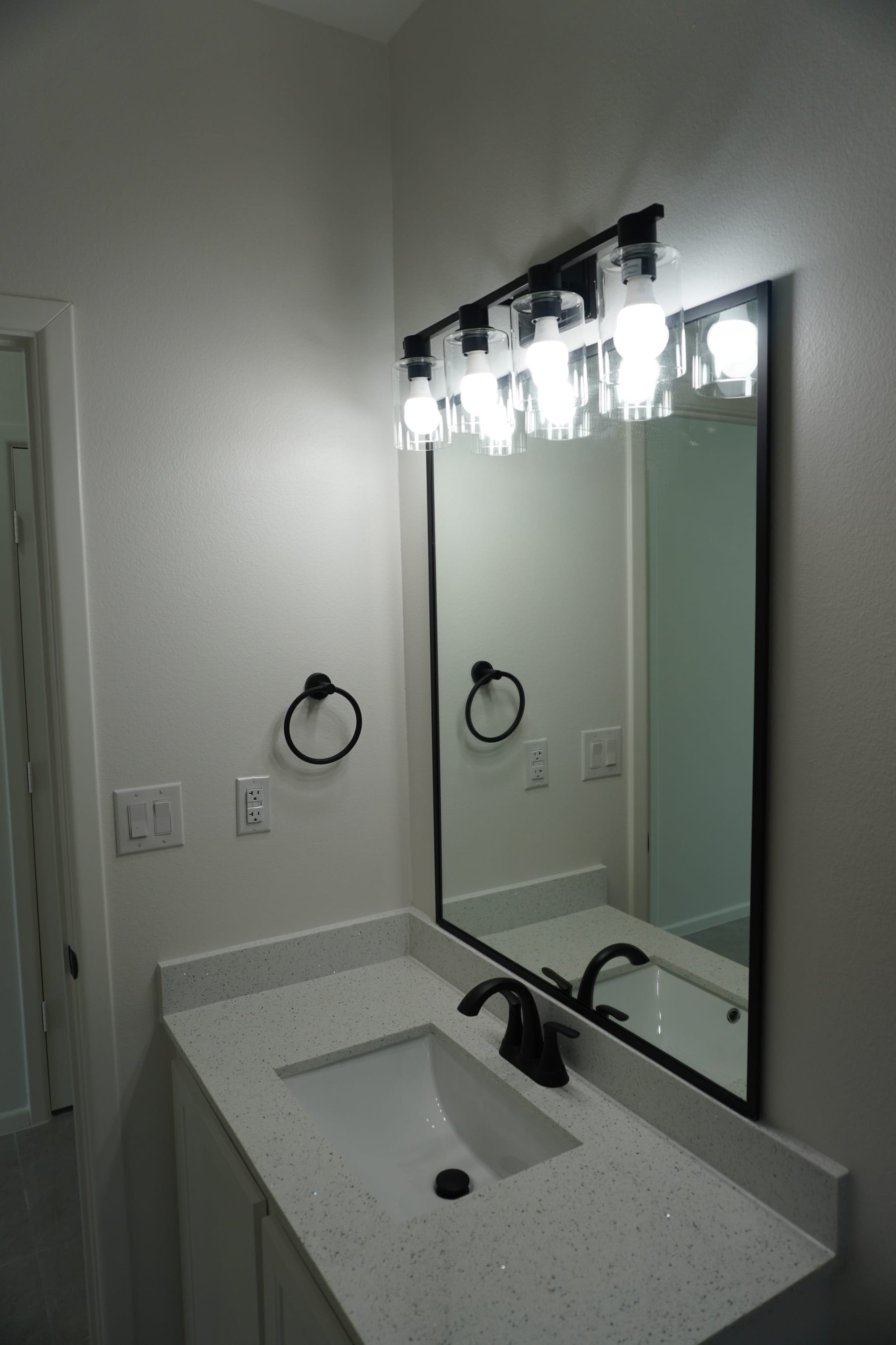 Bathroom vanity with large mirror and modern light fixture