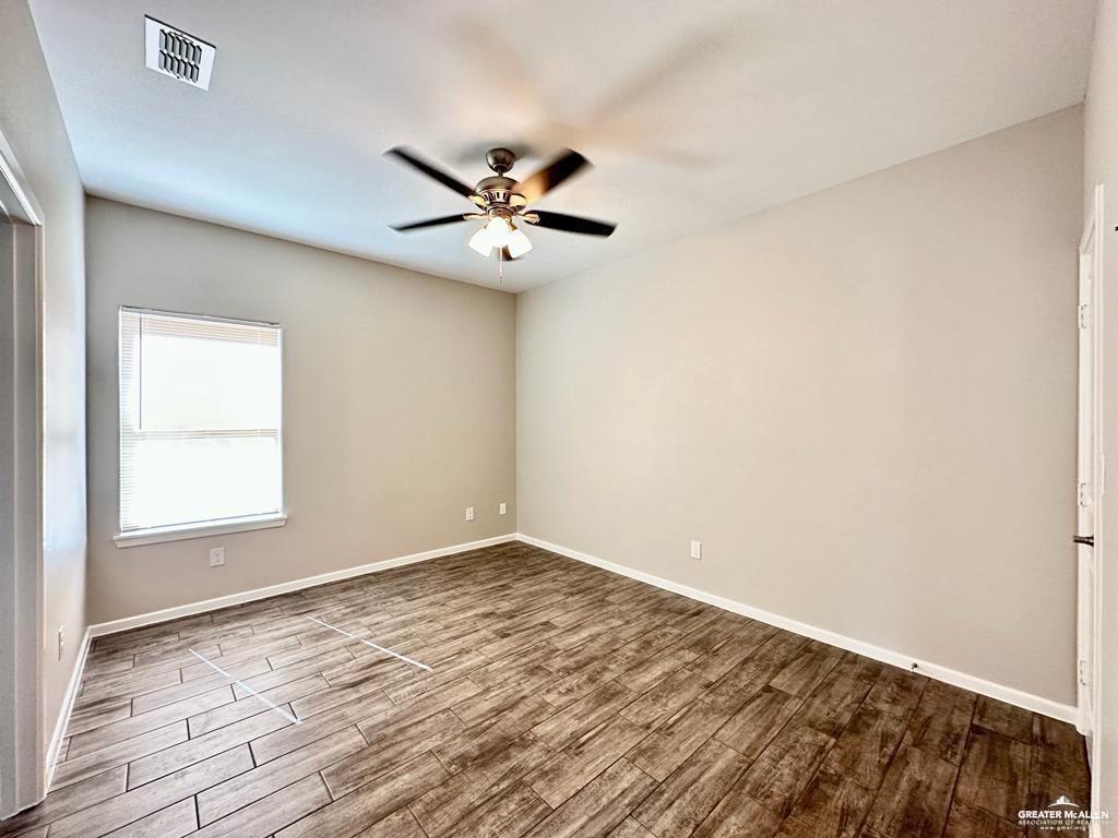 Empty Dawson Estates bedroom with wood-look tile floors, a ceiling fan and one window