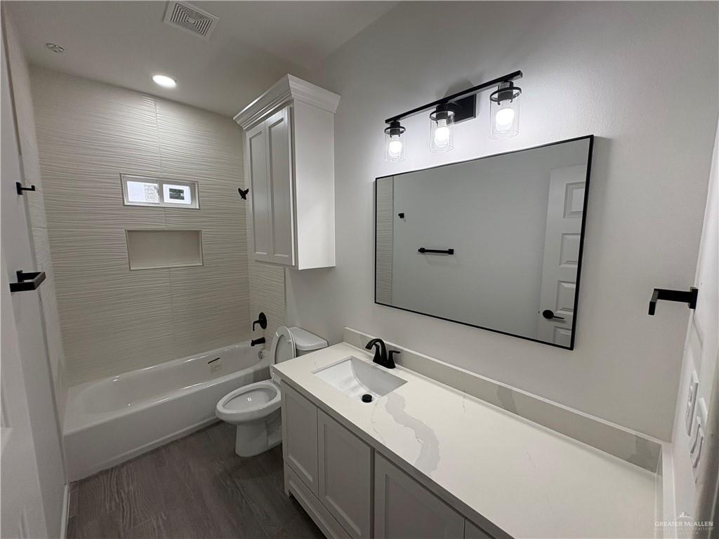 Hacienda Olivia bathroom with a tub and shower, textured white tile and black fixtures