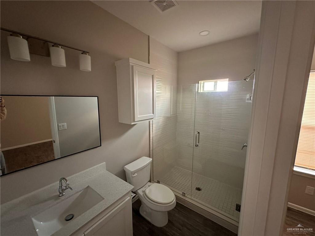 Heights at Alamo bathroom with a glass-enclosed walk-in shower, white vanity and wall cabinet