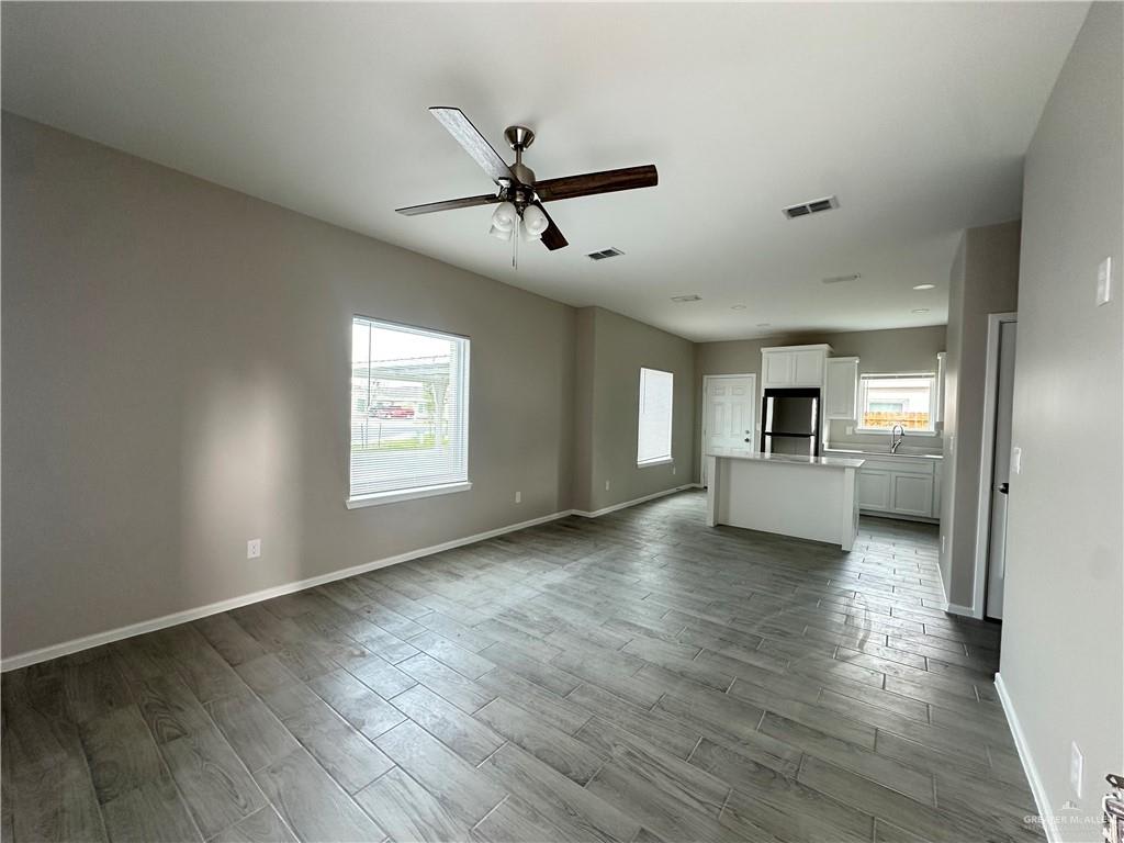 Vida living room with wood-look tile floors and a ceiling fan, looking toward the kitchen island