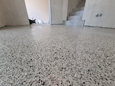 Spīdīga Gaiši Pelēka Epoksīda Pārslu Grīda Ar Kāpnēm Modernā Baltijas Interjerā.