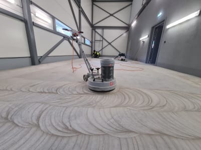 Grīdas Slīpmašīna Sagatavo Betonu Epoksīda Grīdai Plašā Industriālā Noliktavā.