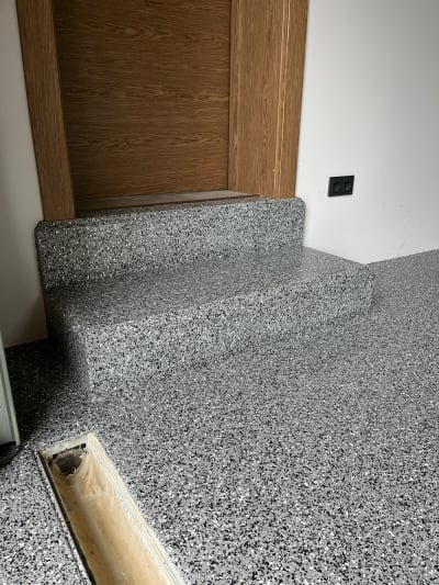 Pelēka Raiba Epoksīda Pārslu Grīda Ar Pakāpieniem, Koka Durvīm Un Grīdas Noteku.